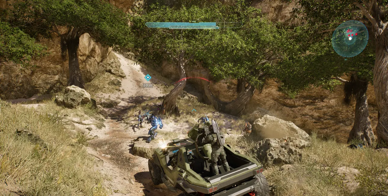 Master Chief riding in a Warthog during a firefight in a forest canyon